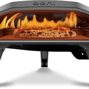 Ooni Koda 16 propane gas pizza oven with the burner lit on a garden table